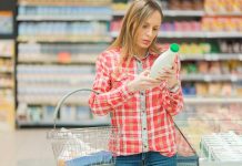 Woman reading label in grocery store aisle