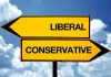 Liberal and conservative road signs against sky background