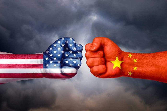 Two fists with US and China flags facing