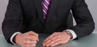 Person in suit with clenched fist on table