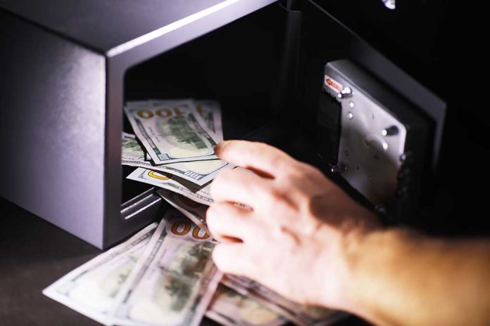 Hand putting cash into a safe