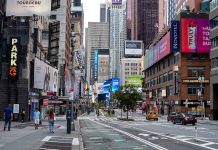 Times Square street scene with storefronts and advertisements.