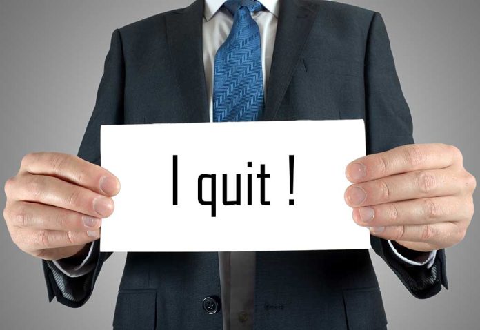 Person holding a sign saying I quit