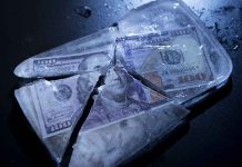 Hundred-dollar bills frozen in cracked ice block