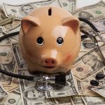 Piggy bank with stethoscope on dollar bills