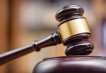 Wooden gavel hitting block in courtroom setting