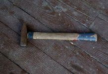 Rusty hammer on a worn wooden floor.