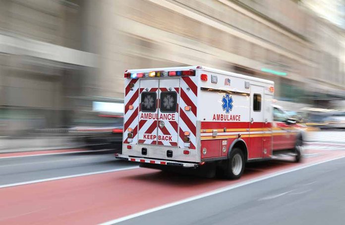 Red and white ambulance driving in the city.