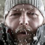 Man in snow with beard and knit hat